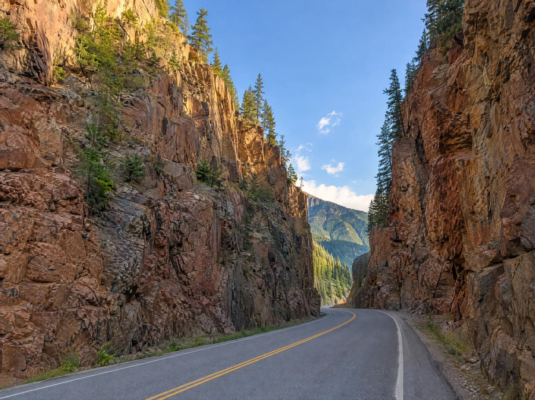 Highway 93 curving between the towering rust-red rock walls of Sinclair Canyon